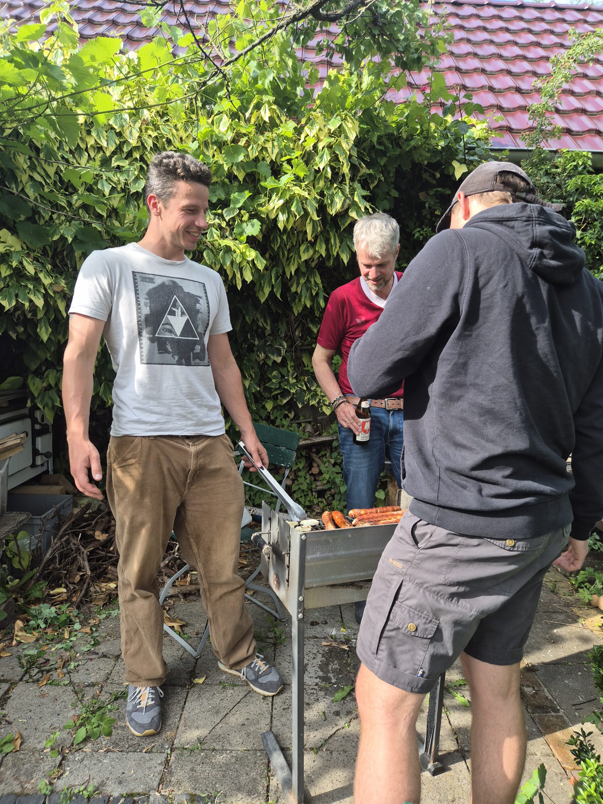 In Toms Garten stehen die Männer am Grill und freuen sich.