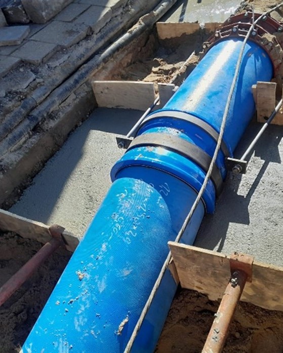 Baustellenbegehung im Rahmen eines Praktikums: Zu sehen ist eine leuchtend blaue Trinkwasserleitung.